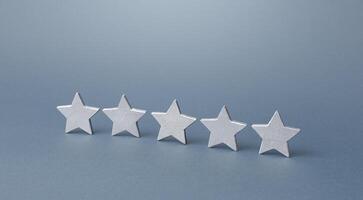 Five gray stars. Rating evaluation concept. Service quality. Buyer feedback. Popularity rating of a restaurant, hotel or mobile software applications apps. High satisfaction. Good reputation status. photo