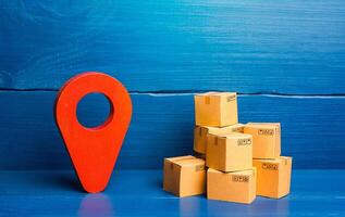 Red location pin pointer symbol and cardboard boxes. Improving the efficiency, speed and low cost of delivering goods to consumer. Business adaptation to quarantine measures, transition to online work photo