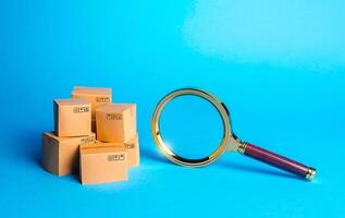 Pile of boxes and magnifying glass. Procurement audit. Monitoring and verification of goods, import certification. Searching goods and components. Quality control. Consumer market research. Tracking photo