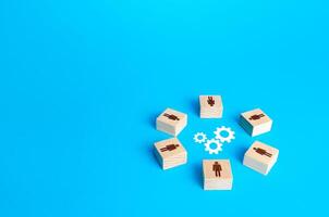 A circle of figures of people surround gears. Brainstorm. Joint efforts to solve problems. Teamwork. Negotiation and dialogue. Development of measures. Working on a common project. Cooperation photo