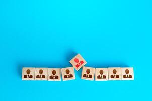 An employee figurine is trying to squeeze in a row. Violation of the optimal team size, reduced efficiency. Non-fitting employee, social toxicity. Low professional suitability and unsuitableness photo