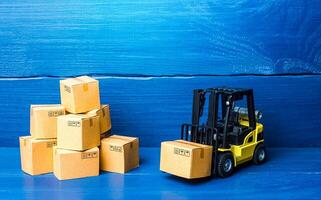 Forklift truck and cardboard boxes with goods. Logistic infrastructure and warehousing services. Transportation transfer industry. Warehouse technologies. Improving low cost efficiency delivery speed. photo