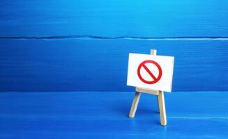 Easel with the prohibition sign NO. Restricted area. Absence. Restrictions and sanctions. Inaccessibility. Ban and Embargo. Failed strategy. Denying entry, stopping action processes. Limitations. photo