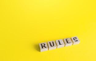 Blocks with the word Rules on yellow background. Laws and community ethics norms. Terms of the contract and the obligations of the parties. Control and monitoring, standardization. Order, discipline. photo