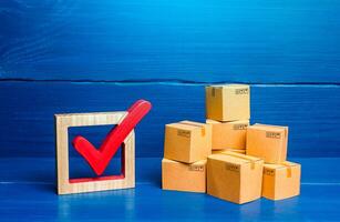 Boxes and red check mark. Verification and standardization of goods and imported products. Quality control. Available in stock. Import and Sale Permits. Trade agreements, turnover transfer convention photo