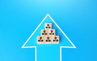 Blocks with people united in a single move arrow. Consolidation for a common goal. Organization cooperation. Strength in unity, teamwork. An effective team focused on getting things done. photo