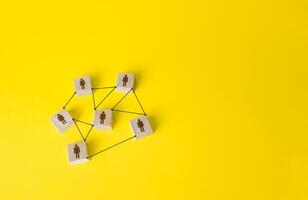 Connected people figures form a working team network. Cooperation and division of responsibilities among project participants. Social communication. An efficient small optimal compact business team. photo