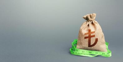 Turkish lira money bag and measuring tape meter. Analysis of economic situation. Declaration of income, illegal enrichment. Formation and optimization of the budget, savings. Assessment of capital. photo
