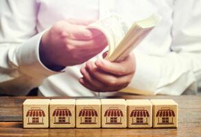 Blocks symbolizing business network and businessman counting money. Building a successful business empire. Expansion and competitive growth. Franchise concession concept. High return on investment. photo