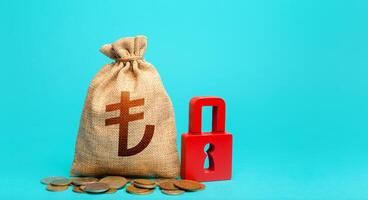 Turkish lira money bag and red padlock. Blocking bank accounts and seizing assets. Freezing of pension savings. Tight government control over the financial system. Cash flow monitoring. photo