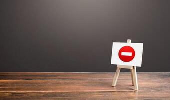 Easel with no entry symbol. Prohibition of actions and operations, restricted area. Ban and sanctions. Isolation zone and quarantine. Wrong direction. Failed strategy. Inaccessibility, taboo. photo