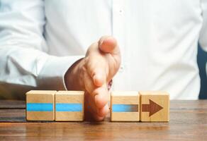Man divides the arrow blocks into two parts. Interruption of the process, decreased activity. Stop financing and supply, slowing down progress. Incompetence and sabotage. Career end. poor performance photo