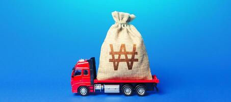 Truck is carrying a huge south korean won money bag. Anti-crisis measures of government. Great investment. Attracting large funds to economy for subsidies, support and cheap soft loans for businesses. photo
