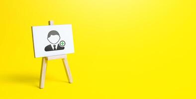 Easel with a new hired employee. Recruiting and HR management. Hiring new workers, staffing. Headhunters and Human Resources. Search for skilled specialists and professionals. Help Wanted photo