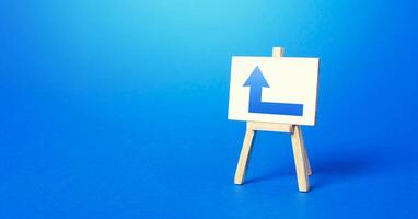 Easel with a blue left arrow. Direction to go around on the right. Advertising, indicating the location of the store object. Minimalism. Navigation, customer acquisition. Copy space photo