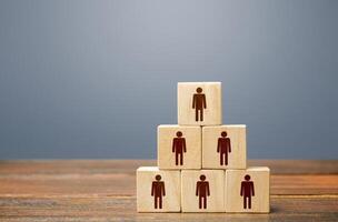 Blocks pyramid with people. Joint efforts to achieve goal. Teamwork, cooperation and collaboration. Team building, company hierarchical power vertical system. Strength in unity. Joining around idea photo