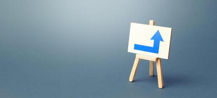 Easel with a blue right arrow. Direction to go around on the right. Advertising, indicating the location of the store object. Minimalism. Navigation, customer acquisition. Copy space photo