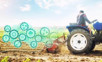 Farmer on a tractor cultivates a farm field and technological innovation gears hologram. Science of agronomy. Farming and agriculture startups. Improving efficiency. Soil milling, crumbling and mixing photo