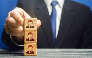 Business leader builds a tower block with employees. Team building, hierarchical power vertical system. Leadership. Effective team Management. Company organization. Hiring and recruiting workers photo