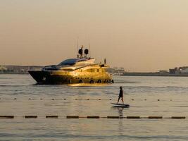 Dubai, UAE - May 28, 2024 expensive yacht is in the Persian Gulf in sanset photo