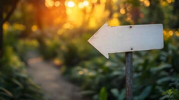 Minimalist white directional arrow sign on metal pole against blurred nature background with bokeh effect, featuring clean design in outdoor forest setting. pole photo