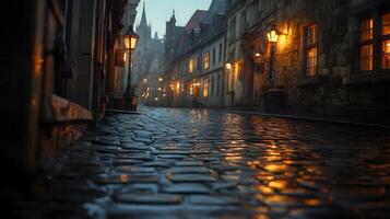 Stone-paved medieval street lined with historic buildings features warm glowing windows and vintage lamps, photographed from low angle in moody evening atmosphere with fog effects. atmospheric photo