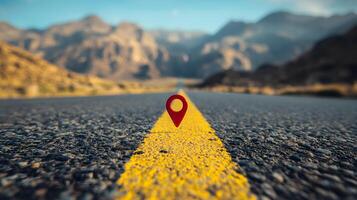 Red location pin marker stands out against yellow road line on empty desert highway, with mountain silhouettes and vibrant blue sky creating cinematic travel scene. travel photo
