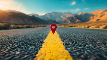 Red location pin marker stands out against yellow road line on empty desert highway, with mountain silhouettes and vibrant blue sky creating cinematic travel scene. destination photo