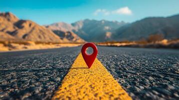 Red location pin marker stands out against yellow road line on empty desert highway, with mountain silhouettes and vibrant blue sky creating cinematic travel scene. exploration photo