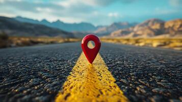 Red location pin marker stands out against yellow road line on empty desert highway, with mountain silhouettes and vibrant blue sky creating cinematic travel scene. discovery photo