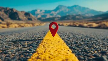 Red location pin marker stands out against yellow road line on empty desert highway, with mountain silhouettes and vibrant blue sky creating cinematic travel scene. placement photo