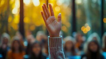 White-sleeved hand raises in classroom environment, representing participation and volunteering against blurred background with warm lighting and educational context. attention photo