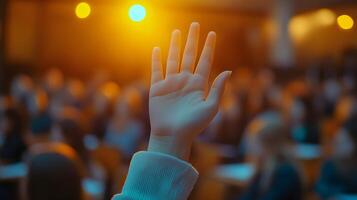White-sleeved hand raises in classroom environment, representing participation and volunteering against blurred background with warm lighting and educational context. interested photo