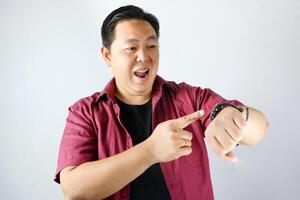 Happy face expression and excited gesture of handsome man pointing his finger to his watch for being on time in important appointment or meeting. photo
