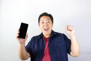 Very happy Man with excited expression while showing blank screen his smartphone, Communication and technology concept. photo