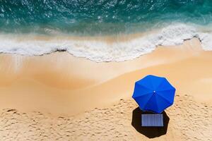 a blue beach umbrella standing in soft golden sand near the shoreline photo