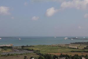 Panoramic Seascape with Ships and Coastal Vegetation Under a Blue Sky With Clouds photo