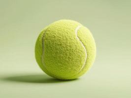 Bright green tennis ball resting on a light green surface with a soft texture and subtle shadows illuminating its shape photo