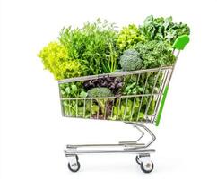 Fresh greens and vegetables fill a shopping cart at a grocery store for healthy meal preparation photo