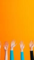 Multiple hands reaching upwards against a bright orange wall, symbolizing unity and enthusiasm in a community gathering photo
