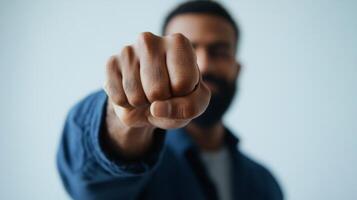 Man showing a clenched fist in a close-up against a soft background while demonstrating determination and strength photo