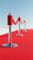 Red carpet and stanchions set up for a glamorous event with bright blue sky background photo