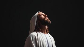 Spiritual figure Jesus Christ with serene expression gazes upward against dark background during quiet moment of reflection photo