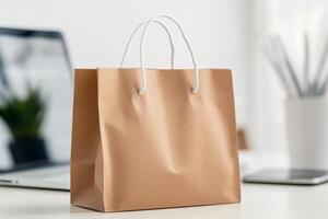 Simple brown paper shopping bag on a desk with modern office accessories and technology visible in the background photo
