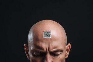 Digital slavery, digital concentration camp, social problem of the future concept. Man concentrates with a QR code displayed on his bald forehead in a dark setting photo