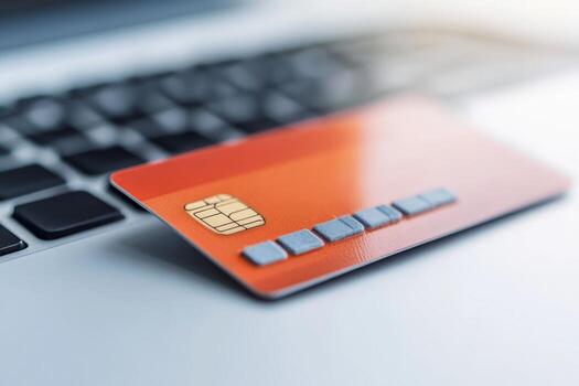 Credit card placed on a laptop keyboard suggesting online shopping and digital transactions in a modern workspace photo