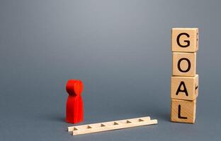 Person near Goal blocks tower and a fallen ladder. Using tools to solve problems, achieve success. Developing strategy. Attracting investment and financial resources for a successful business startup. photo