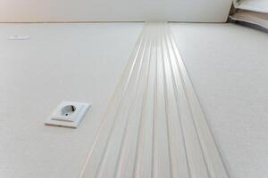 Next to the electrical socket, the immaculate white stripes on the floor serve to significantly enhance the cleanliness and aesthetic appeal of the entire area, making it more inviting photo