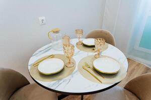 A beautifully arranged round table adorned with elegant plates and sparkling glasses effortlessly creates a warm and inviting atmosphere, making it perfect for enjoyable dining experiences photo