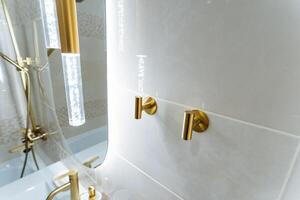 The bathroom is equipped with essential amenities that include a sink, a shower, and a mirror, creating a comfortable and highly functional space for all kinds of daily hygiene routines photo